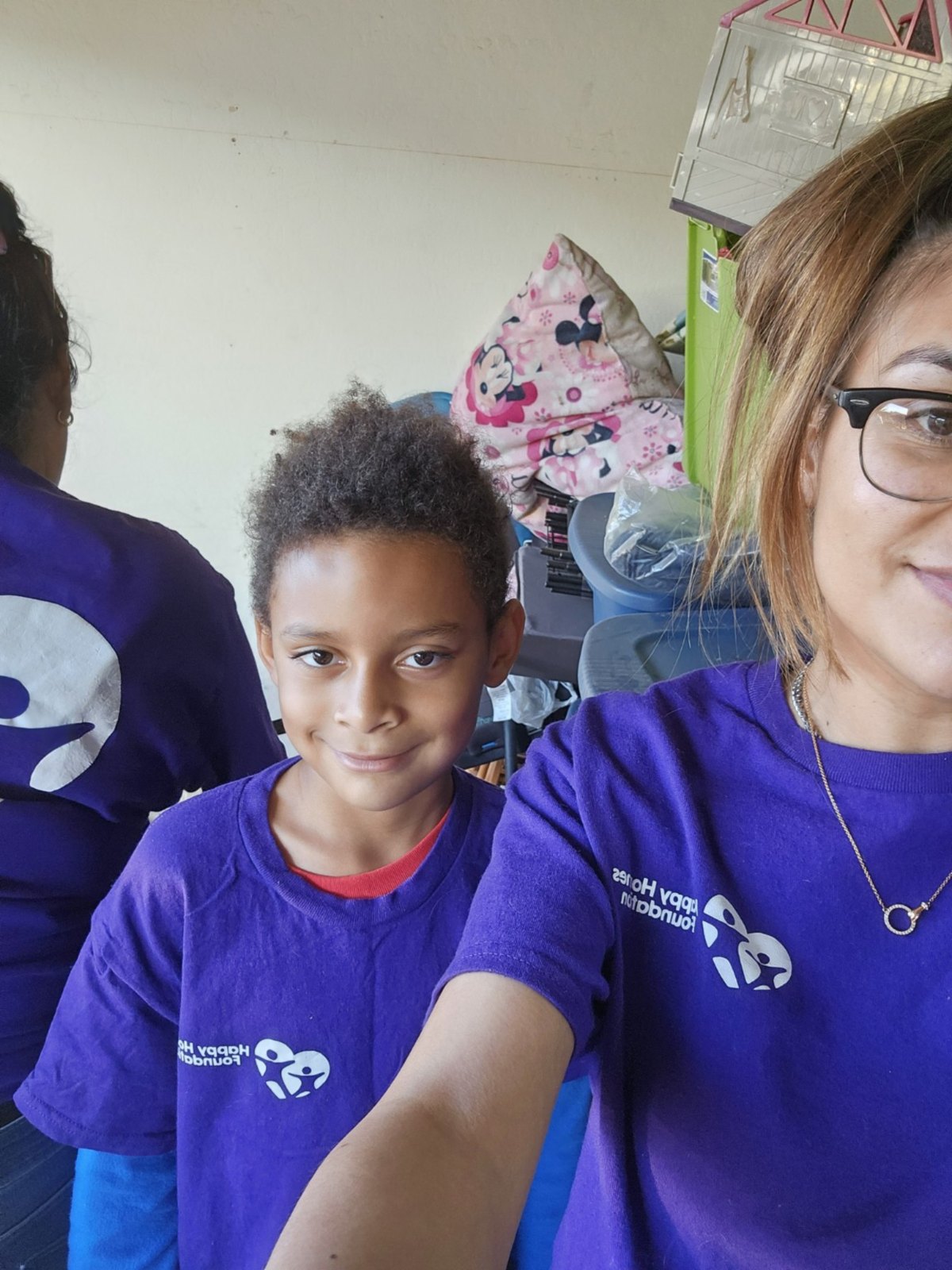 Child and volunteer wearing Happy Homes Foundation shirts